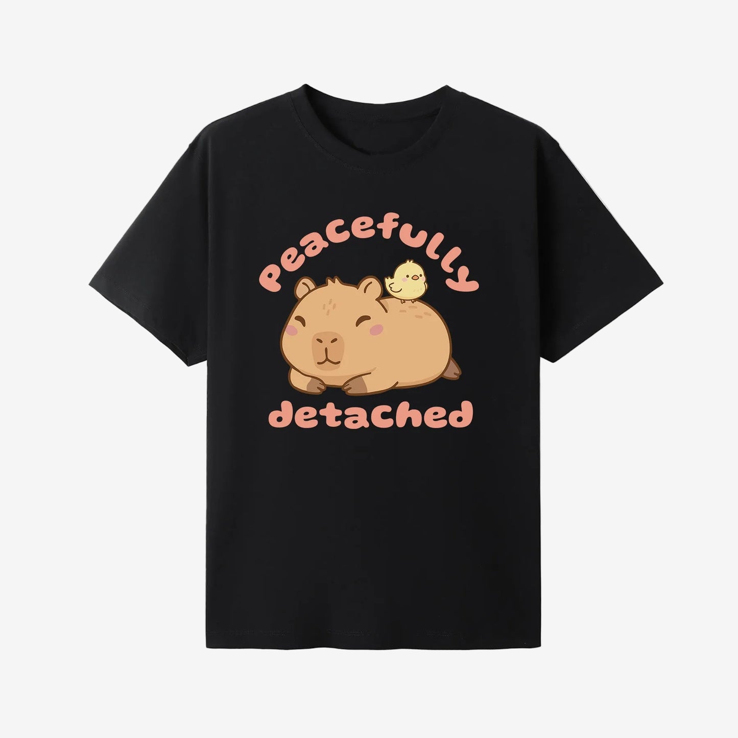 Black t-shirt with a cartoon capybara and text 'Peacefully Detached' on a white background