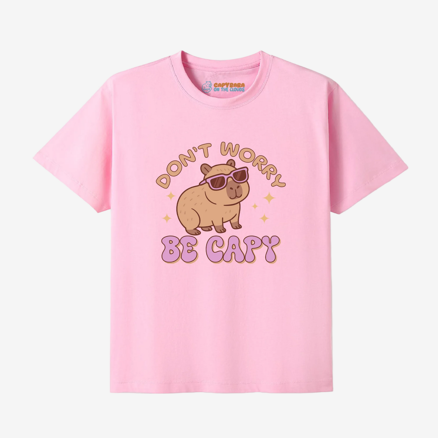 Image of a pink tshirt with the words don't worry be capy and an illustration of a capybara wearing sunglasses