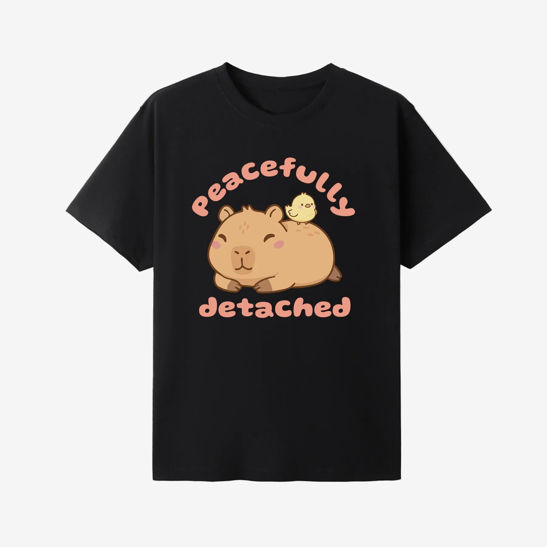 Black t-shirt with a cartoon capybara and text 'Peacefully Detached' on a white background