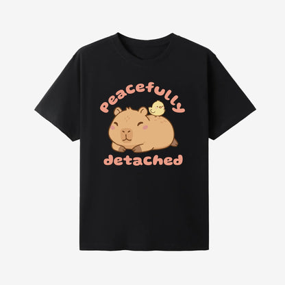 Black t-shirt with a cartoon capybara and text 'Peacefully Detached' on a white background