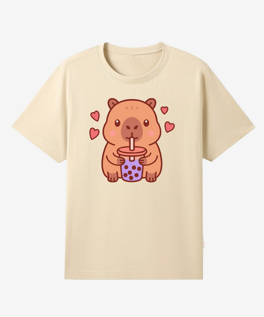 Beige t-shirt with a cartoon capybara drinking from a cup on a white background