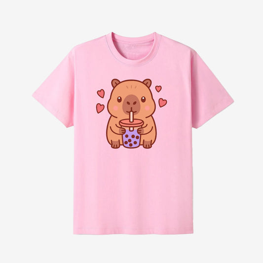 Pink t-shirt with a cartoon capybara design holding a drink, on a white background