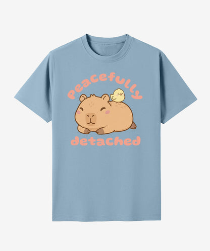 Light blue t-shirt with a graphic of a capybara and text 'peacefully detached' on a white background